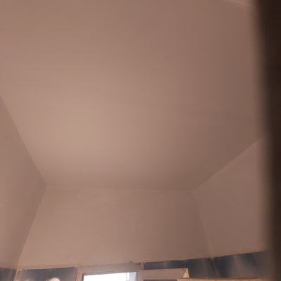 קיר גבס לבן עם חלון קטן למטה