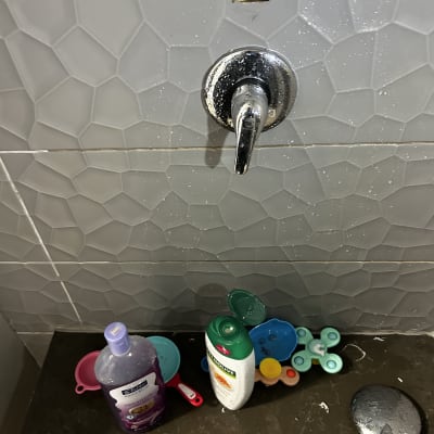 ברז מים עם כלים וחומרי ניקוי על משטח