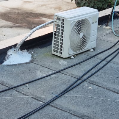 צינור אטום בחומר לבן ליד מזגן על גג