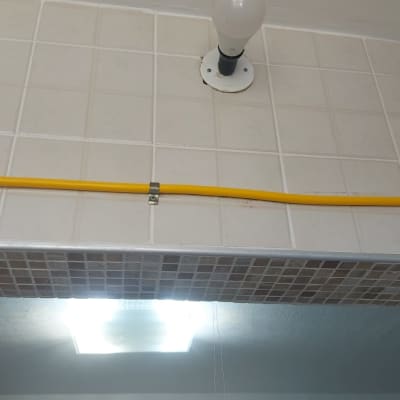 צינור גז צהוב מותקן על קיר אריחים