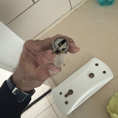 יד מחזיקה מנעול שבור על רקע שולחן