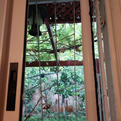 חלון אלומיניום עם סורגי מתכת וגינה ברקע