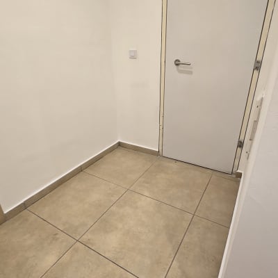 קיר ודלת צבועים בלבן עם רצפת אריחים