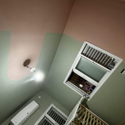 קיר צבוע בשני צבעים עם חלון ומנורה