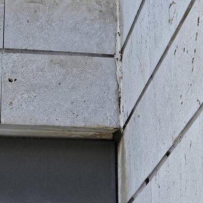 קיר בטון עם סימני רטיבות ונזילות בפינה