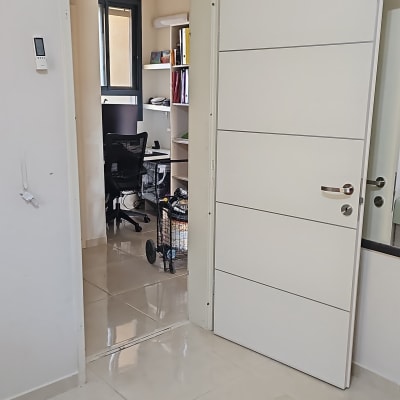 דלת לבנה פתוחה לחדר עם ריהוט משרדי