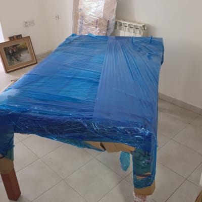 שולחן עטוף בניילון כחול למעבר דירה