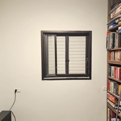 חלון עם מסגרת שחורה על קיר לבן