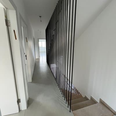 מעקה מתכת שחור לאורך גרם מדרגות פנימי