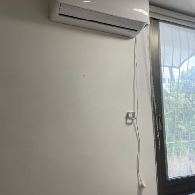 מזגן מותקן על קיר ליד חלון