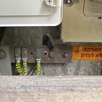 חיבורי חשמל עם שלט אזהרה על הארקה
