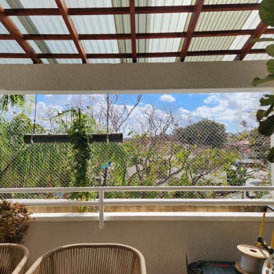 רשת יונים מותקנת במרפסת עם צמחייה מסביב