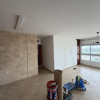 חומרי צביעה וכלים בחדר ריק עם קיר צבוע