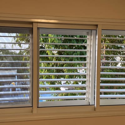 תריסים לבנים נקיים על חלון גדול