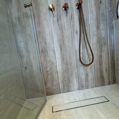 מקלחת עם קיר עץ וברזים מוזהבים