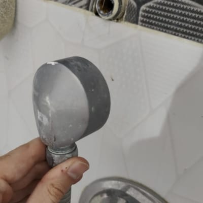 יד מחזיקה צינור מקלחת מנותק מהקיר