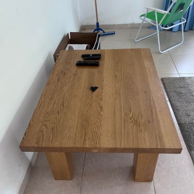 שולחן עץ עם שלטים על רצפה מרוצפת