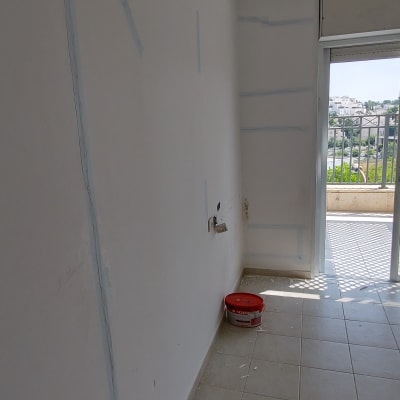 קיר עם סימני צבע ודלי צבע על הרצפה