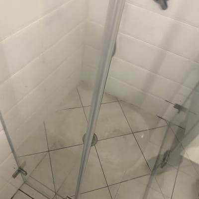 מקלחון עם דלת זכוכית ורצפת אריחים