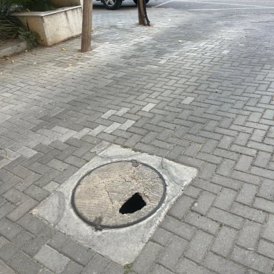 פתח ביוב שבור על מדרכה