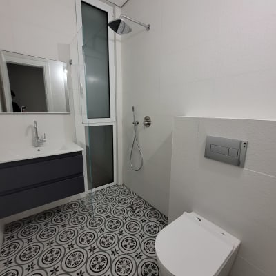 חדר אמבטיה נקי עם מקלחת, כיור ואסלה