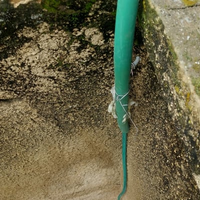 כבל ירוק מחובר לקיר עם חוט מתכת