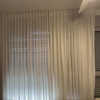 וילון לבן שקוף תלוי על חלון עם אור מאחוריו