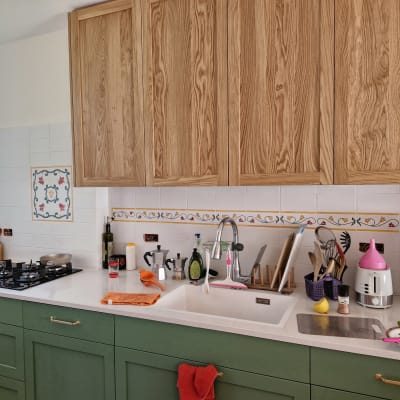 מטבח עם ארונות עץ, כיור וכלי מטבח שונים