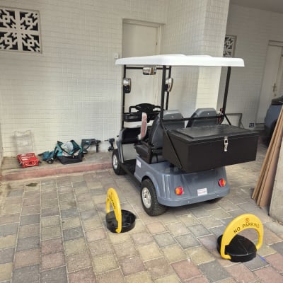 רכב גולף עם כלי עבודה וחסימות חניה צהובות