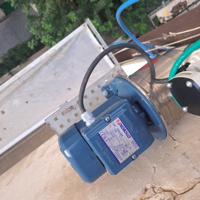 משאבה כחולה עם צינורות מים מחוברים