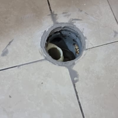 צינור ביוב חשוף ברצפה עם אריחים