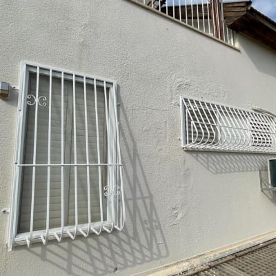 חלונות עם סורגים לבנים על קיר חיצוני