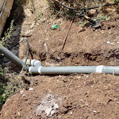 צינורות פלסטיק באדמה עם כלי עבודה