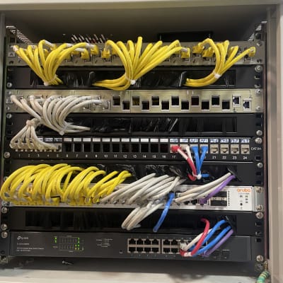 ארון תקשורת עם כבלים צהובים ולבנים מחוברים למתגים