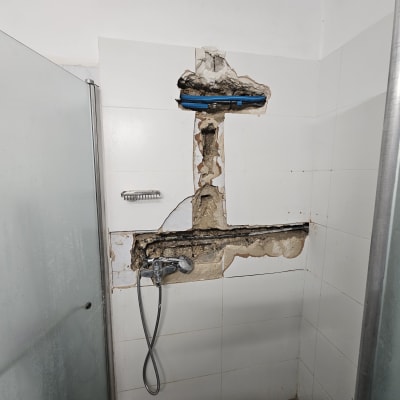 תיקון צנרת בקיר מקלחת עם אריחים שבורים