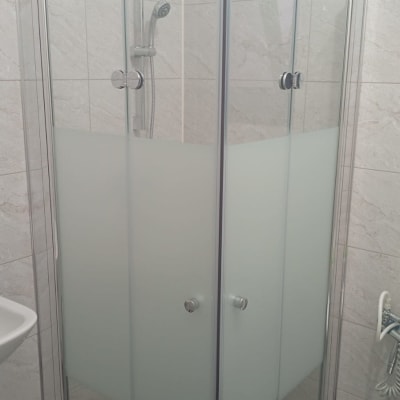 מקלחון זכוכית עם דלתות שקופות וראש מקלחת