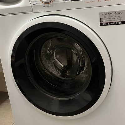 מכונת כביסה עם לוח בקרה ותווית שירות חשמל