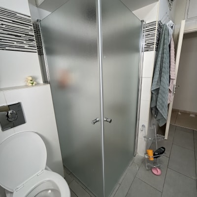 מקלחון זכוכית עם דלתות מט, מתלה מגבות ליד