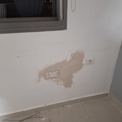 שקע חשמל בקיר עם תיקון טיח וחוטי חשמל