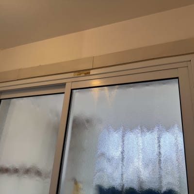 חלון זכוכית חלבית עם מסגרת מתכת בתהליך שיפוץ