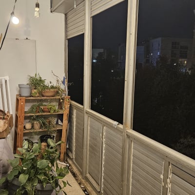 תריסים סגורים במרפסת עם צמחים ותאורה