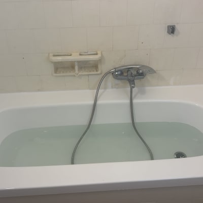 אמבטיה עם מים וברז מותקן על הקיר