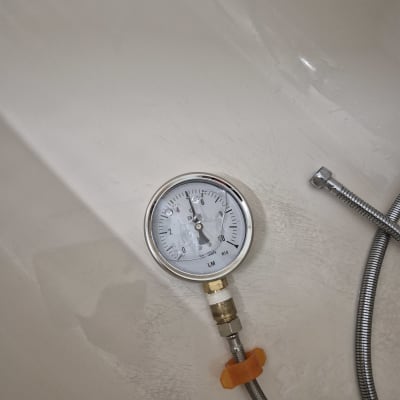 מד לחץ מחובר לצינור מתכת גמיש