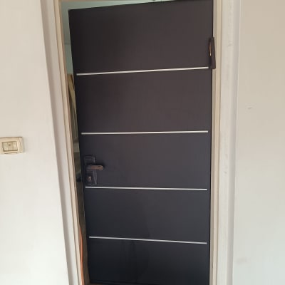 דלת כהה עם ידית מתכת ופסים אופקיים