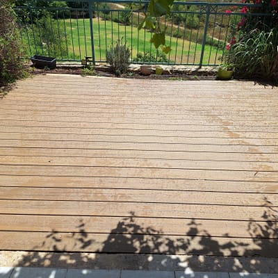 דק עץ עם עציצים קטנים וגדר מתכת