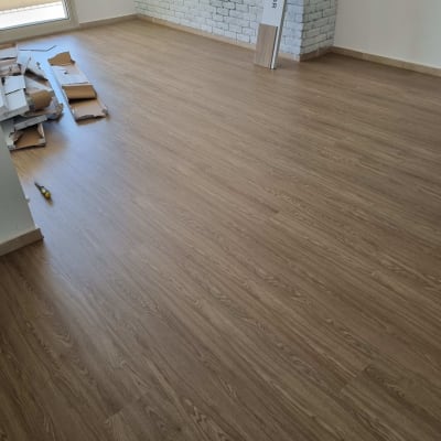 רצפת פרקט עץ בחדר עם קיר לבנים