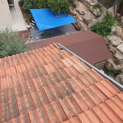 רעפים כתומים על גג עם לכלוך וכתמים