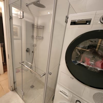 מקלחון זכוכית עם ראש מקלחת עגול ומדף מתכת