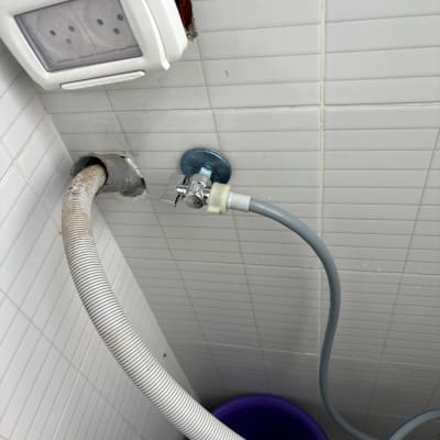 צינור מים וברז על קיר אריחים לבנים