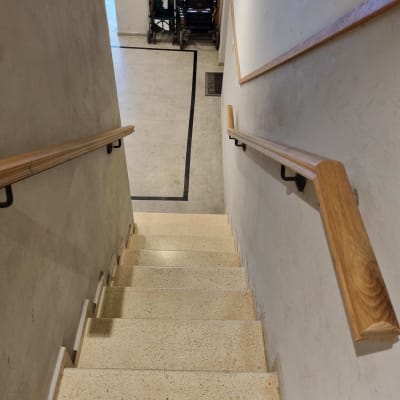 מדרגות עם מעקה עץ ועגלות ילדים למטה